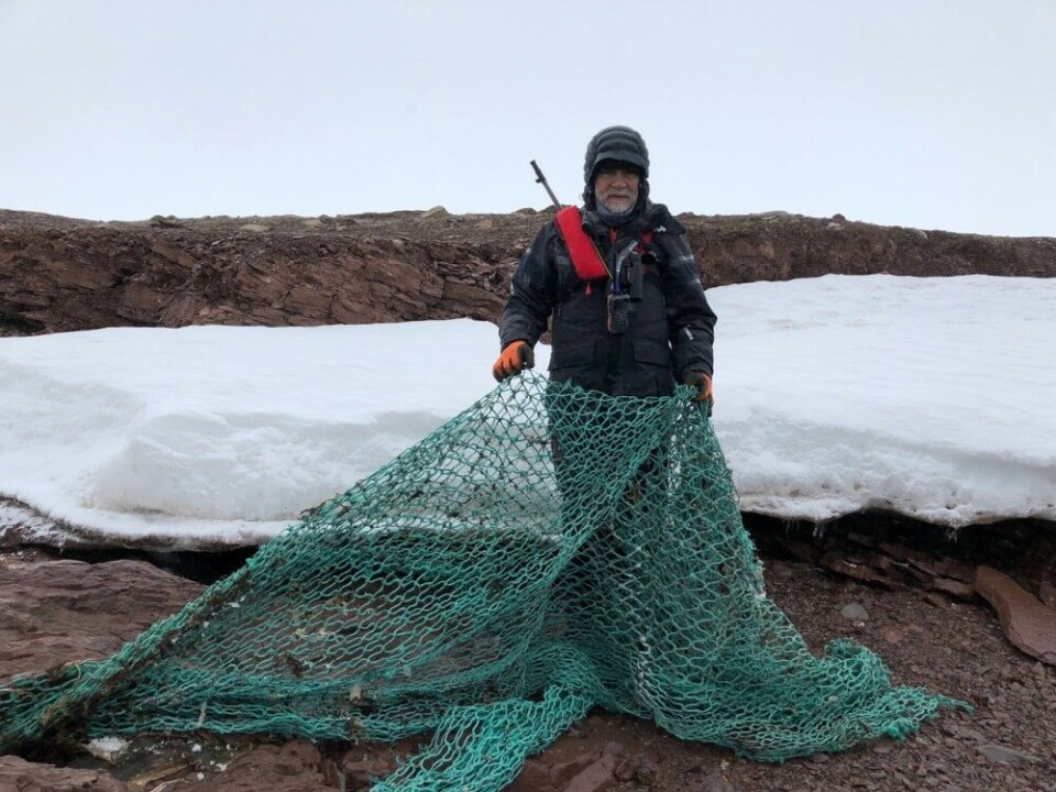Mats Forsberg shows a fishing net and tells similar once can be found on shores all around Svalbard. Photo: Paul Tomasko