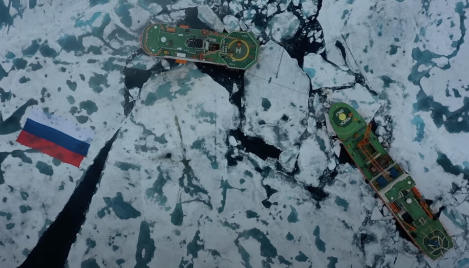 The flag is surrounded by two scientific icebreakers “Severny Polyus” and “Akademik Tryoshnikov”. Photo: Screenshot from the Arctic and Antarctic Research Institute video