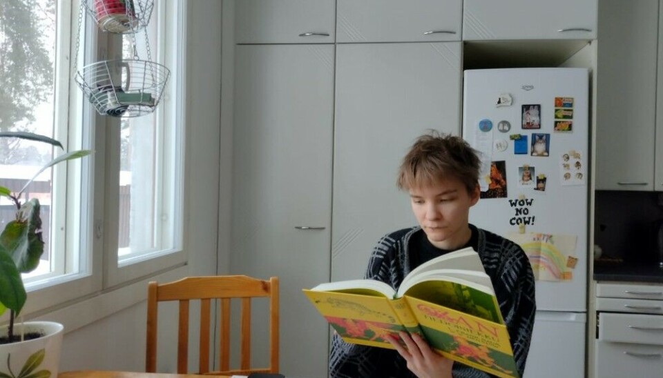 Project coordinator Milla Tynnyrinen reading a book in Karelian language. Photo: University of Eastern Finland