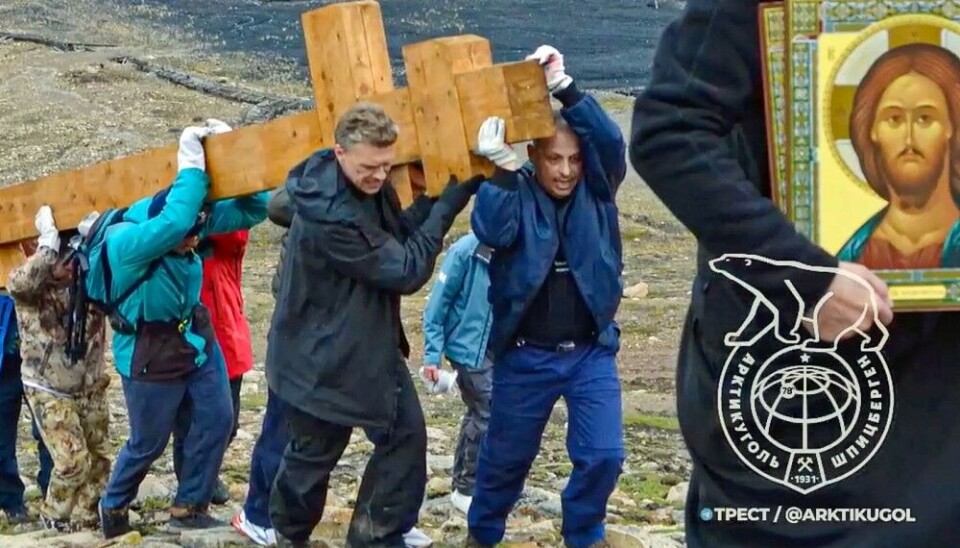 Ильдар Неверов (слева спереди) помогает нести гигантский православный крест, который установили на склоне сопки над Пирамидой в августе. Кадр из видео, размещенной на странице треста «Арктикуголь» во «Вконтакте»