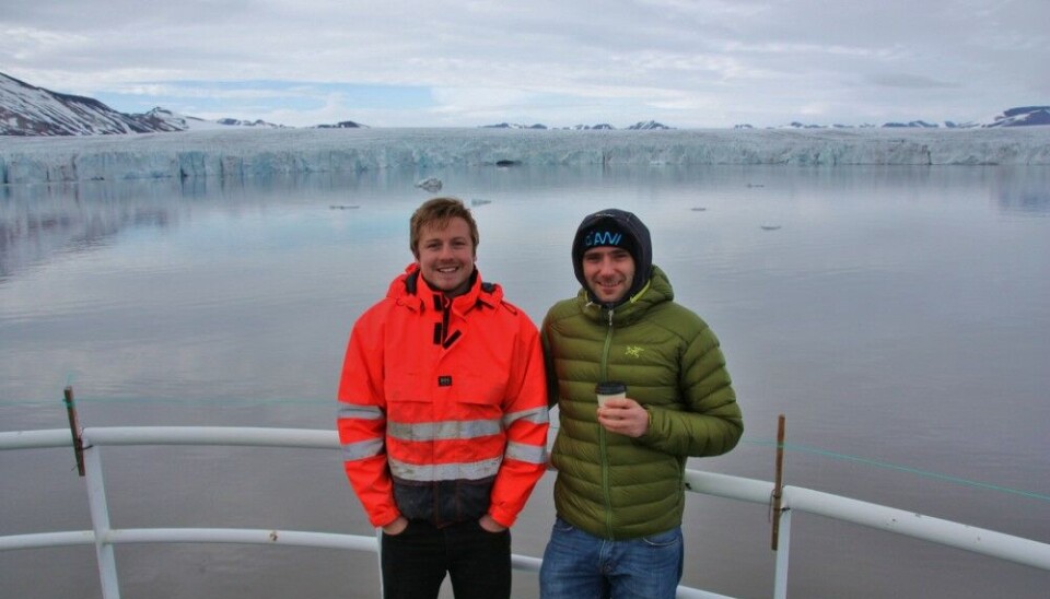 From left to right: scientists Calvin Shackleton and Henry Patton onboard Helmer Hanssen with a glacial fjord in Svalbard in the background. Photo by Mariana Esteves
