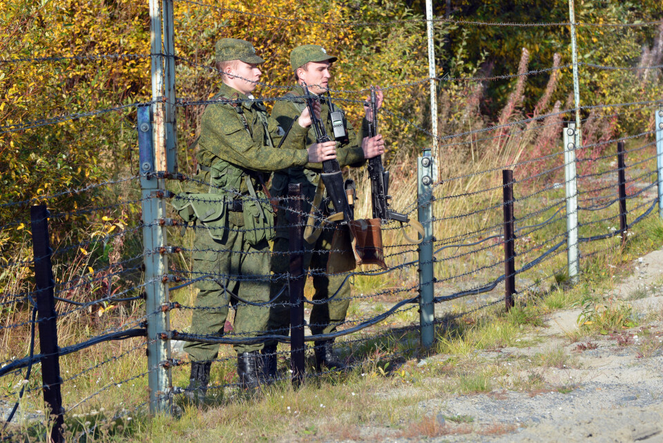 Two officers from FSB’s border guard service at the barbed wire fence near the border to Norway. Photo: Thomas Nilsen