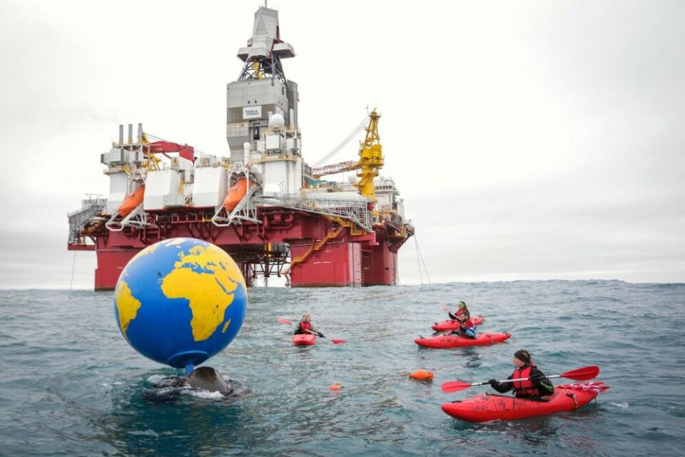 Four activists in kayaks near the rig, bringing a huge globe with messages to end Norway’s Arctic oil expansion. Photo: Greenpeace