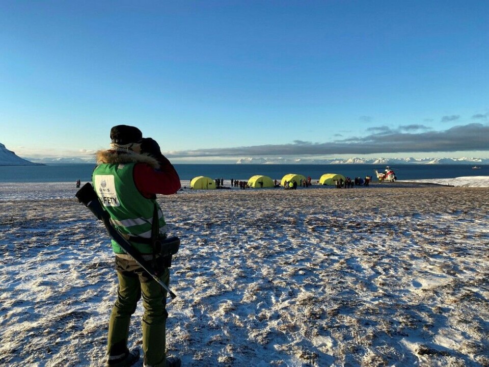 A polar bear guard on watch: People airlifted with helicopter off the ship were taken onshore, where rescue personnel had erected tents. Photo: Nora Hagesæther / Norwegian Space Agency