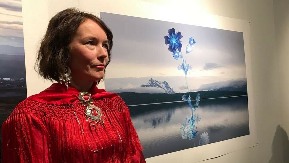 Marja Helander and her photograph “Sacred and mysterious” at the exhibition Viidon sieiddit – The New Dimensions of the Sámi Relationship to Nature. Photo: Ritva Torikka / Yle