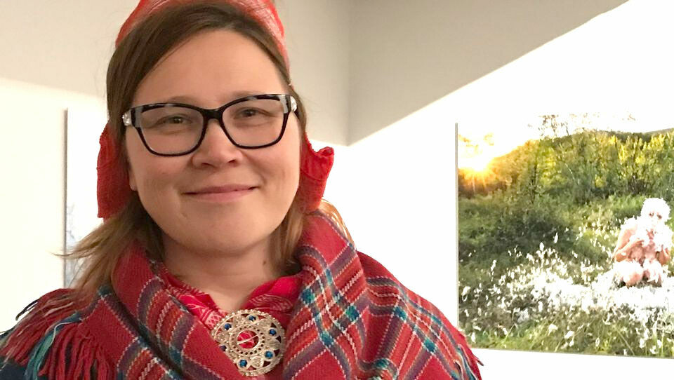 According to Elle Máret Näkkäläjärvi, a visit to the exhibition inspired her to reflect on many things. Behind her, a photograph by Marja Helander. Photo: Ritva Torikka / Yle