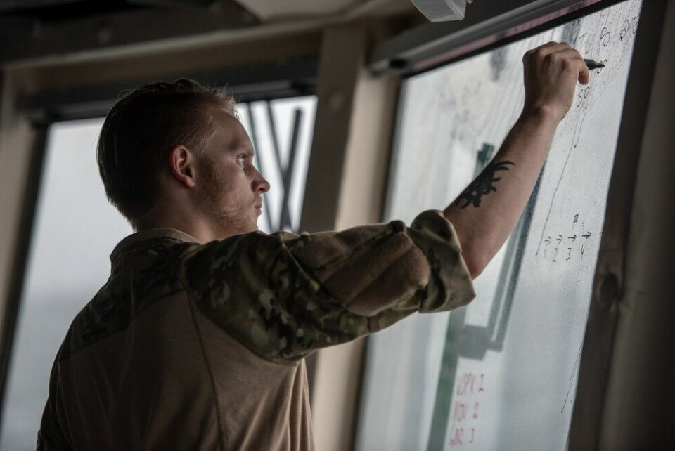 A Danish Navy sailors writes ships names on one window aboard SNMG1 Flagship HDMS Niels Juel, during Dynamic Mongoose 18. NATO Photo by FRA N WO Christian Valverde