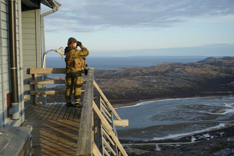 A Norwegian military border guard on watch at OP 247, looking out towards the Barents Sea. Russia's Sredny Peninsula visible in the horizon. The land-border goes in Grense Jakobselv. Archive photo: Thomas Nilsen