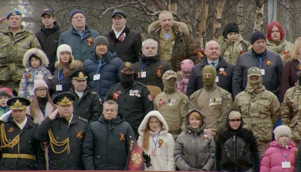 Masked warriors with uniforms and Wagner patches on the parade honorary stand. Screenshot of video