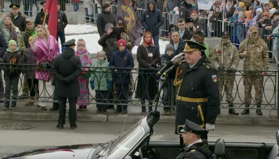 Wagner fighter waves with flag as Northern Fleet head commander Kabantsov drives by. Screenshot of video