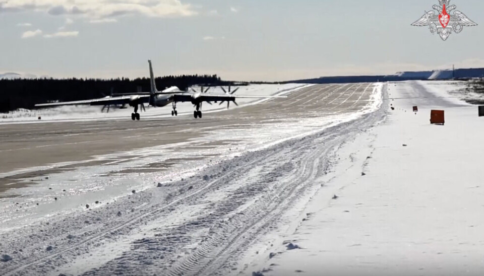 Приземление одного из двух стратегических бомбардировщиков на авиабазе Оленья на Кольском полуострове в среду днем. Справа на горизонте видны отвалы расположенного в Оленегорске горнодобывающего предприятия. Кадр видео Министерства обороны РФ