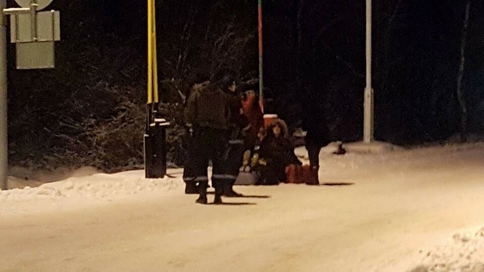 Two migrants sit down on the borderline as Norwegian police try to return them to Russia and Russian border guards refuse to accept them. Photo: Thomas Nilsen