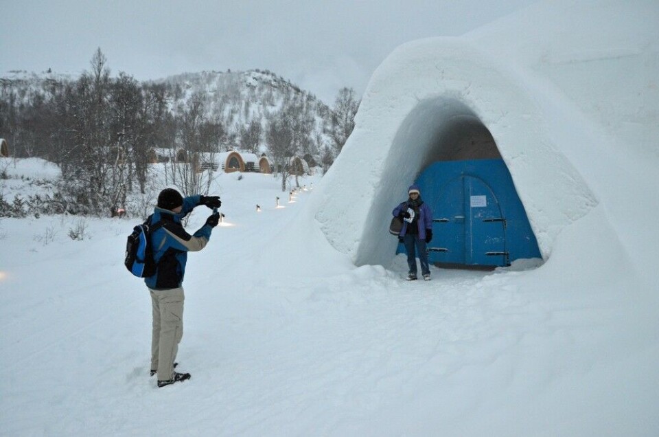 Tourists from South-Africa taking photo at the entrance to the Kirkenes Snowhotel. Photo: Thomas Nilsen