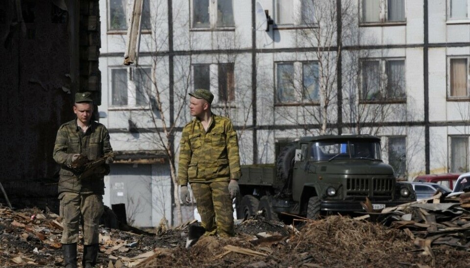 Рабочие сносят старые дома в Корзуново, полузаброшенном военном городке рядом с танкодромом 200-й отдельной мотострелковой бригады, дислоцированной на территории Печенгского района Мурманской области. Фото: Томас Нильсен