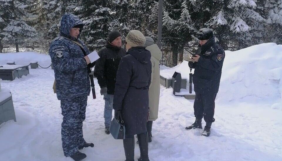 Полицейские записывают данные людей, пришедших почтить память Алексея Навального в Сыктывкаре.