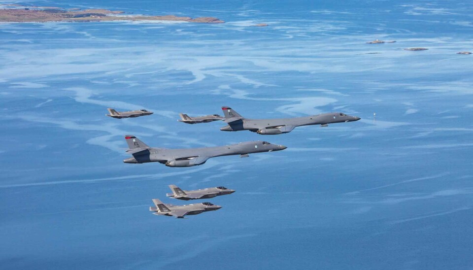 Two US B-1B Lancer bombers flying in formation with Royal Norwegian Air force F-35A fighters.