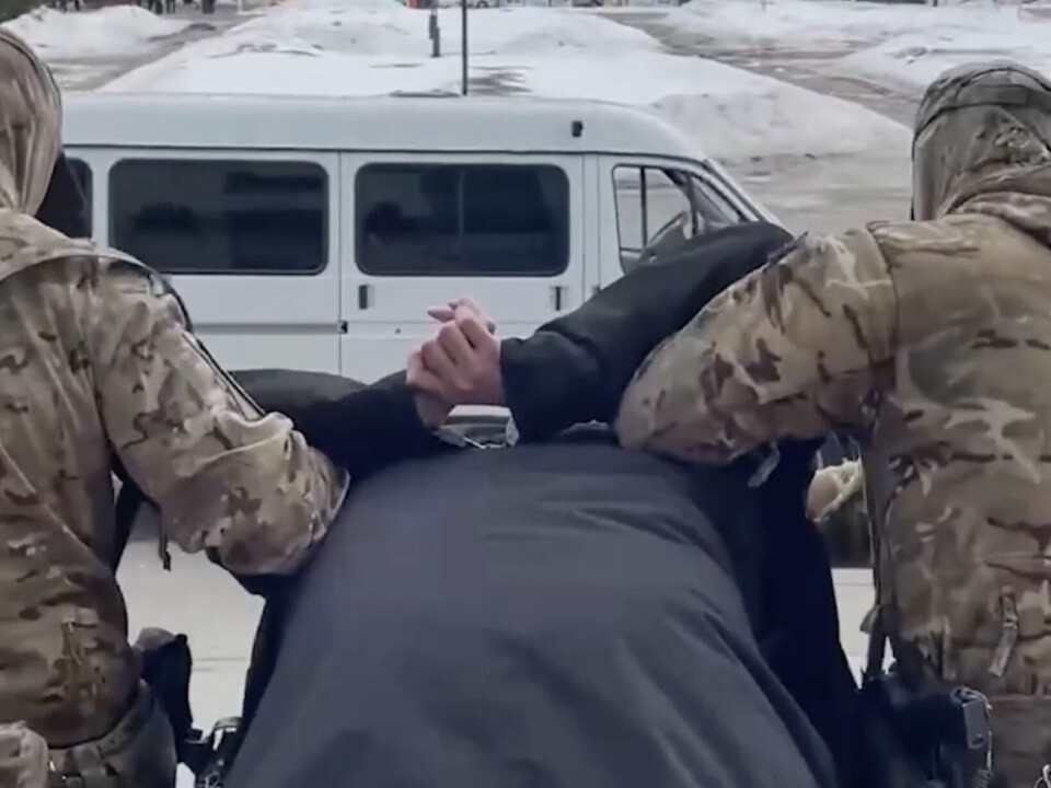 A man is brought out of his office in the 24-story building in the centre of Arkhangelsk. Judging from the amount of snow, the arrest happened in March.