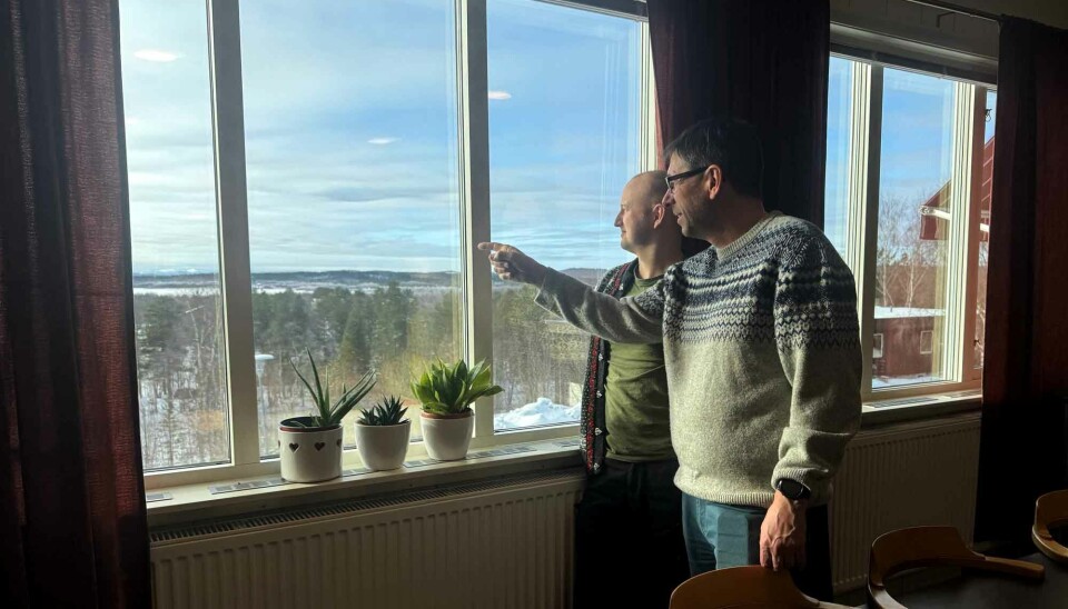 Rector Ketil Foss and teacher Vegard Seljemo look across the Pasvik River and towards Russian border town Nikel.