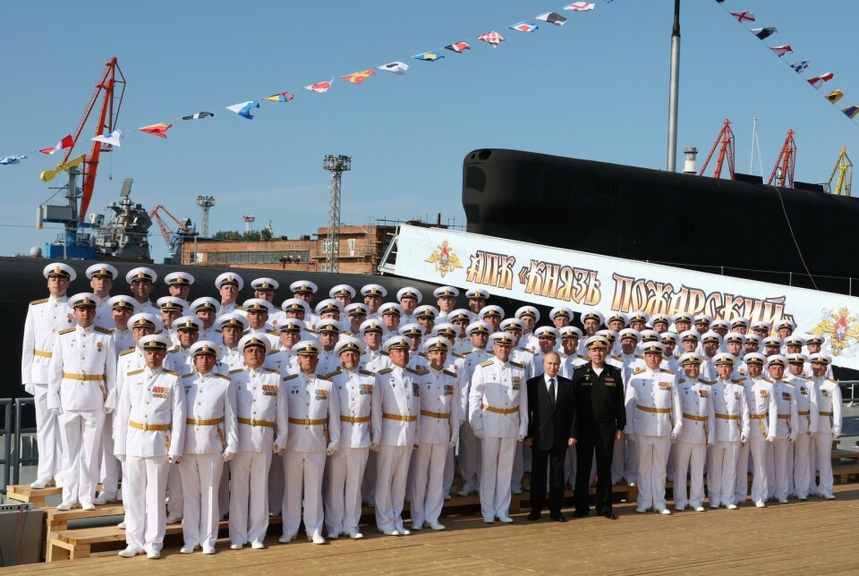 Vladimir Putin and Commander-in-Chief of the Russian Navy, Admiral Aleksandr Moiseev, (men in black) lined up with the crew of the Knyz Pozharsky at the Sevmash yard on July 24.