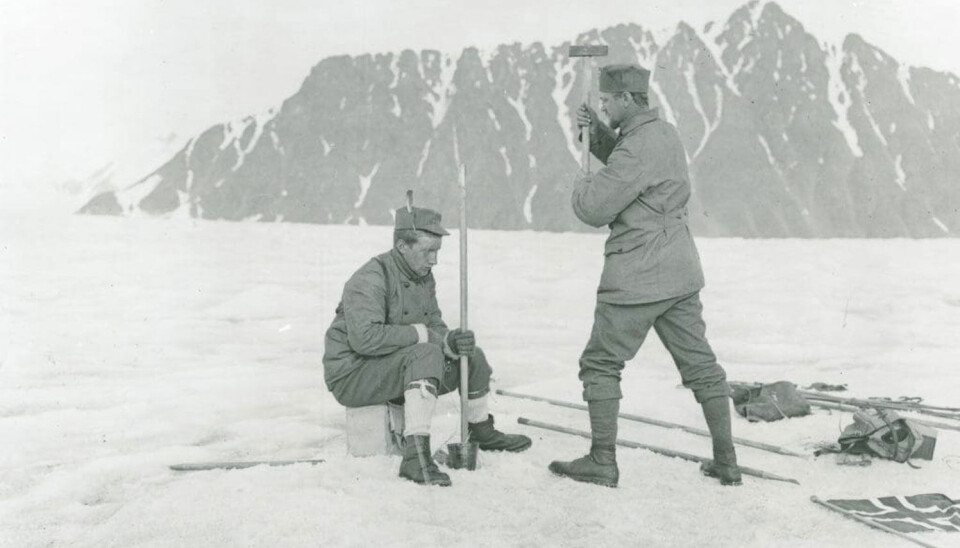 Adolf Hoel pounding a tent pole into the ice of Lillehöökbreen in 1907, probably to hold a flag.