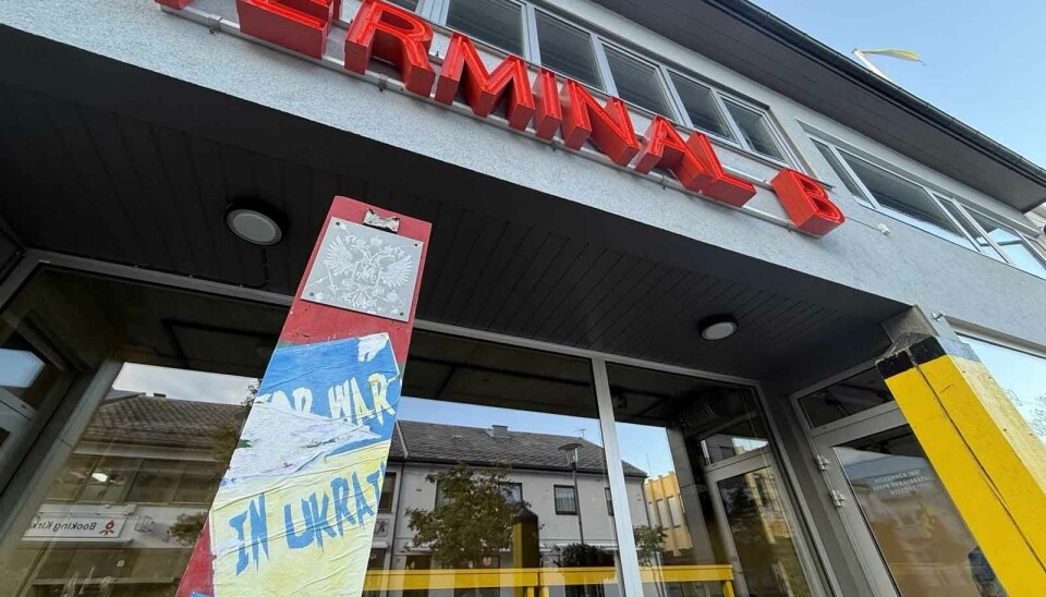 A Russian border pole with the two-headed eagle in front of the offices of Pikene på Broen in Kirkenes. A poster that reads 'Stop war in Ukraine' has been partly removed.