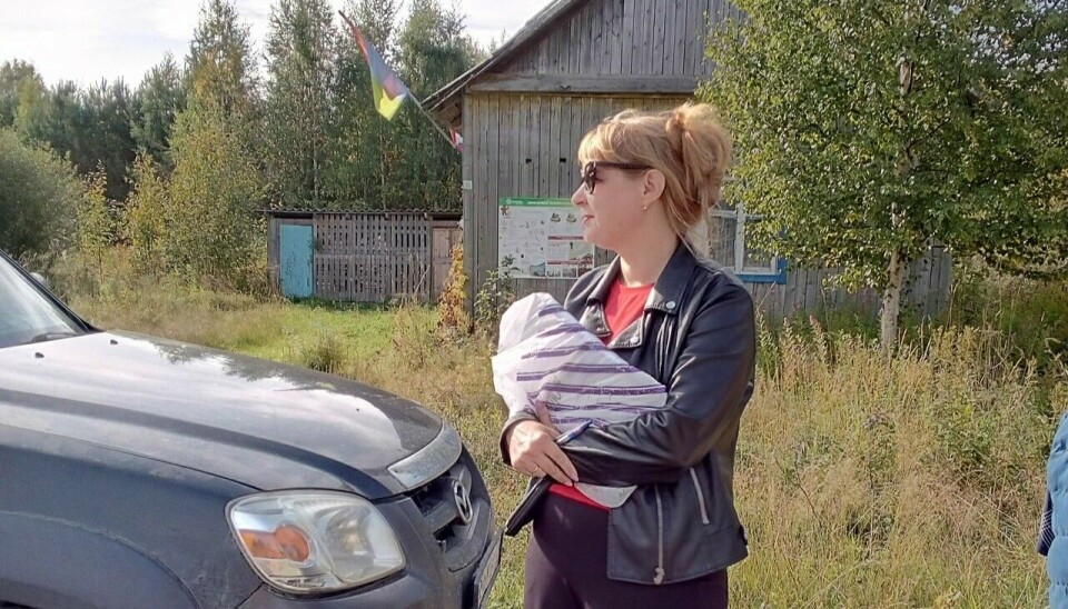 Член избирательной комиссии в поселке Ахвенламби прижимает к груди пачку с бюллетенями, которые вскоре выдадут избирателям.