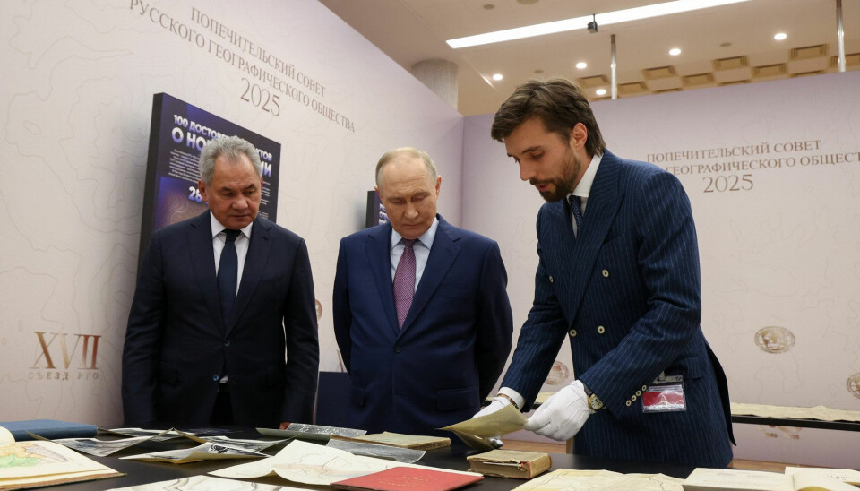 Vladimir Putin and Sergei Shoigu look at historical maps of Russian expansion.